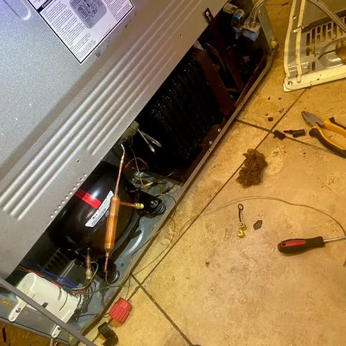 Reviews: Compressor and wiring at the back of a refrigerator during a repair
