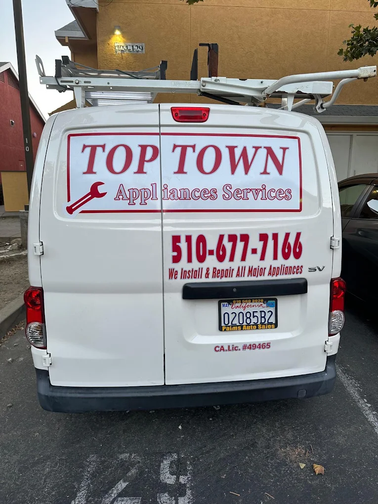 Rear of the Top Town Appliance Services van with its roof ladder rack