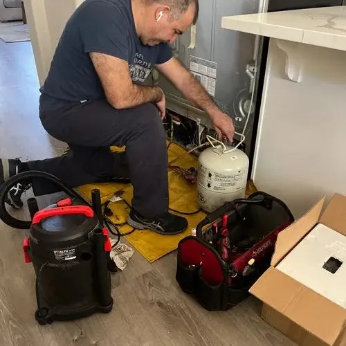 Top Town technician working on the back of an appliance at a customer home